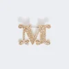 Broche con monograma adornado con cristales, blanco óptico Broche con monograma adornado con cristales, blanco óptico