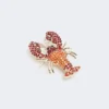 Broche de metal con pedrería, rojo oscuro Broche de metal con pedrería, rojo oscuro